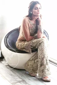 A straight short shirt with having Round neckline features beautiful embellishments on the neckline. Embellished border implemented at the bottom of shirt. Sleeves contain embroidered motifs on the cuff. Banarsi Jamawar Bell bottom pants. Dupatta contains stones spray all over and Edges finished.