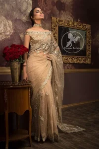 Banarsi jamawar blouse contains embroidered border on the neckline. Net saree contains flourishing embellishments all around the edges. Stones spray scattered all over the saree. Large motif implemented at the centre of saree.