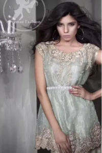 The shirt has been adorned with an embellished neckline. A large work border is implemented at the bottom of the shirt. The shirt comes with embroidered waist belt. Stones spray scattered all over the shirt. Trousers contain embroidered borders at the bottom. Work includes kora, dabka, stones, sequins, beads, silk threads, and Swarovski crystals.