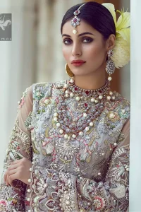 Ivory white long fitted bridal maxi. Maxi adorned with colorful embellishment using appliques and threads. Bridal maxi comes with two tones dupatta having peach and ivory white shades.