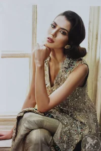 Grey olive floral embroidered high and low front open short frock. Frock is finessed with kora, dabka, pearls, sequins and swarovsky. The daman of the frock is beautifully enhanced with scalloped border and silhouettes. This shirt is adorned with 3D floral embroidered motifs having V shaped neckline. Top is coordinated with pajama having embroidered motifs.