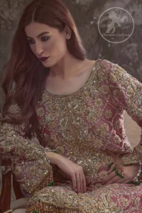 Copper Rose Shirt Vanilla Trousers. It is adorned with a criss-cross design. This shirt is meticulously highlighted with dull golden and antique shaded kora, dabka, tilla, sequins and pearls.