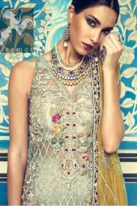 This shirt is decorated with resham threads, kora, dabka, tilla, sequins and pearls. The shirt is beautifully decorated with self embroidered criss cross pattern. It is further enhanced with embroidered scalloped border which adds to the look. It comes with brocade bell shaped trousers. It is beautifully coordinated with organza mehndi colored dupatta, allured with four sided embellished appliqued border.