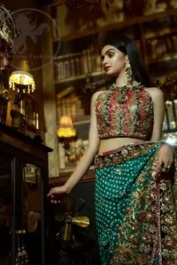 This outfit is a timeless beauty. It is heavily embellished with antique gold kora, dabka, tilla, sequins and swarovski crystals. This exquisite halter neckline blouse is fully decorated with floral motifs patterns all over it. Applique waist belt is decorated with gota and thread embroidery.It comes with embellished lehengha. This Outfit is beautifully coordinated with lime yellow dupatta with heavy embroidered borders.