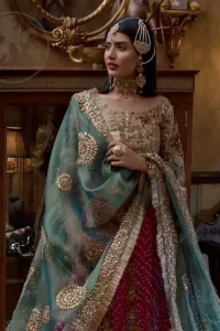 This outfit is a timeless beauty. Its blouse is heavily embellished with silver gold kora, dabka, sequins and swaronski crystals. This exquisite blouse is fully decorated with floral motifs patterns all over it. Boat shaped neckline add to the look. It comes with shocking pink chunri lehenga which has small sized sprinkled floral motifs all over. This outfit is beautifully coordinated with organza dupatta. Dupatta is embellished with kiran lace and gotta work on sides.