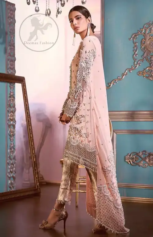 This outfit is decorated with silver kora, dabka, tilla, sequins and pearls. This dress is embellished with floral embroidery and