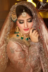 Feel glamorous in antique brass short shirt with fascinating embellishment on neckline with golden kora dabka, tilla and pearls. Floral motifs on sleeves add to the look. It is stunningly coordinated with traditional golden gharara. Complete the look with tilla work organza dupatta finessed with embroidered borders.