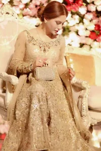 Delicately crafted and personifying chic elegance with an element of grandiose. This pretty gold embroidered frock done with kora dabka, tilla, diamante and sequins. Hemline edges are fully decorated with pearls. It comes with Brocade Pajama and Net dupatta sequins spray all over.