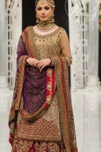 This bridal dress is perfect for your special day. Exude elegance in this chiffon shirt finessed with beautiful embellished daman and neckline, done with antique shaded kora dabka, tilla, sequins and pearls. Lehenga comprises of floral embroidery adorned with thick embellished border. It comes with purple dupatta with embroidered borders on all sides and sequins spray on the ground.