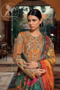 A jaffa color shirt heavily embellished in the front with antique shaded kora dabka, kundan, tilla, sequins and pearls. Floral motifs on the shirt and cold shoulder sleeves enhance the beauty of this shirt. It is finished with scalloped embellishment border. This dress is coordinated with embroidered cigarette pants and self-printed dupatta.
