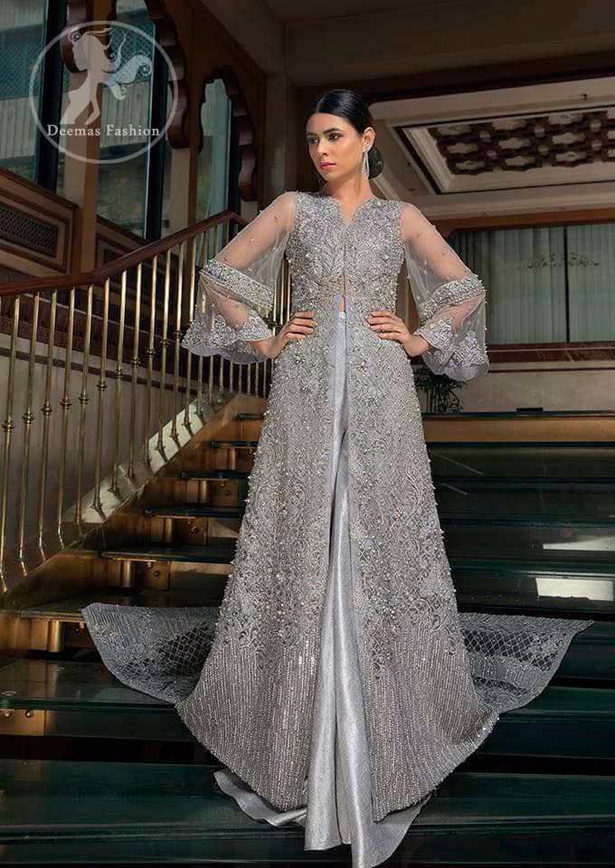 This dress is timeless beauty. Light gray, dress with heavy embellishment with swarovski crystals and silver work in sequins, kundan and kora dabka. The back trail is allured with intricate embroidered patterns and floral motifs. It is finished with light gray sharara.
