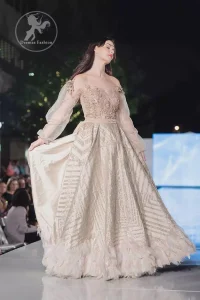 This dress is timeless beauty. The sweetheart neckline is decorated with intricate stones and sequins. Antique shaded kora dabka enhanced the beauty of bodice. Off shoulder sleeves enhanced the beauty of this maxi. Waist belt add to the look. It is paired up with antique white churidar pajama.