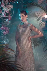 This dress is decorated with floral embroidery. It is highlighted with kora, dabka, tilla, sequins and pearls. Back trail frock adds to the look. It is allured with shamoz lining. It is coordinated with shamoz sharara. It comes with chiffon dupatta which is sprinkled with sequins all over it.