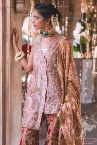 This outfit is executing heavily handcrafted art of zardozi. It is allured with kora, dabka, tilla, sequins and pearls. It comes with raw silk dupatta which is fully embellished. It comes with an exquisite high and low short shirt with thick embroidered borders to give it a regal look. This outfit is artfully coordinated with bell bottom embroidered trousers.