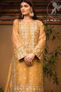 This dress is allured with floral embroidery. It is further enhanced with gota, kundan, sequins and pearls. It comes with organza lehengha. It is artistically coordinated with velvet shawl, having four sided embellished scalloped border.