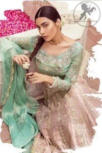 The bridal stands out due to its uniqueness and the perfect fusion of modern cut and traditional embroidery. This dress is beautifully decorated with heavy embroidery. It is highlighted with dull golden kora, dabka, tilla, sequins, pearls and thread embroidery. This outfit comes with salmon pink lehenga which is enhanced with embroidery on bottom. It is coordinated with tissue dupatta which is sprinkled with sequins all over it. It is further furnished with four sided scalloped border.