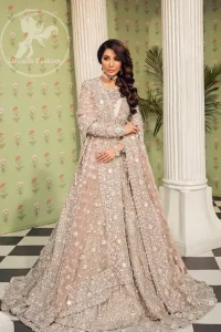 This outfit is a timeless beauty. Exude elegance and class in this full embroidered chiffon frock with zardosi work details and rich hemline. It is adorned with heavily embellished neckline and fixed waist belt. It comes with beautifull lehenga enhanced with thick embellished bottom to gives it a regel look.  This outfit is coordinated with net dupatta sprinkled with floral motifs all over it. The dupatta incorporates beautifully designed borders on all four sides, focusing on the heavily embellished pallu borders to give it a perfect look.