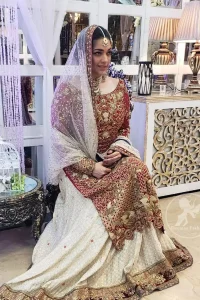 Make a dazzling impression in our zari embroidered copper rust shirt enhanced with intricately embellishmentswith gold and antique gold kora, dabka, tilla, sequins and pearls.It is paired up with thread embroidered chiffon lehengha having appliqued border around. Dupatta is sprinkled with stones all over it.