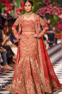 This dress is beautifully decorated with heavy embroidery. It is highlighted with dull golden kora, dabka, tilla, sequins and pearls. Fish lehengha is fully embellished.Blouse is scalloped. It comes with beautifull upper gown, sprinkled with sequins all over it. It is coordinated with chiffon dupatta which is sprinkled with sequins all over it.