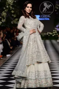 Feel glamorous in our ivory back trail frock with fascinating embellishment on neckline with silver kora, dabka, pearl and sequins. The detailed embellishment at the daaman instantly draws attention. It comes with an exquisite lehenga with thick embroidered borders to give it a regal look. The outfit is finished by beautiful applique embellished lehenga. It is coordinated with tissue dupatta which is sprinkled with sequins all over it. It is further furnished with four sided embellished border.