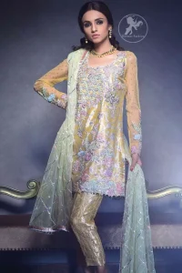This dress is beautifully decorated with heavy embroidery. It is highlighted with dull golden kora, dabka, tilla, sequins and pearls. Fish lehengha is fully embellished.Blouse is scalloped. It comes with beautifull upper gown, sprinkled with sequins all over it. It is coordinated with chiffon dupatta which is sprinkled with sequins all over it.