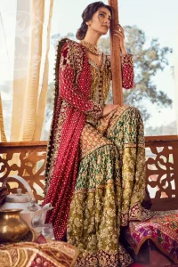 Exquisite detailing radiates elegance in this stunning short shirt. Redefine your style in this traditional and versatile ensemble ornamented with floral and geometric embroidery furnished with golden kora dabka, kundan and pearls. It comes with multiple colored traditional gharara done with zerdozi work in patterns and embroidered applique details on bottom. Complete the look with red dupatta having embroidered borders on all sides and sequins spray on the ground.