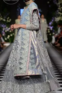 Boost your confidence and style in this glamorous attire accentuated with finest zardosi work embroidery and cut work neckline. It is beautifully decorated with heavy embroidery. It is highlighted with silver kora, dabka, tilla, sequins and pearls. It comes with heavily embroidered lehenga which is decorated with red piping from the bottom. It is coordinated with tissue dupatta which is sprinkled with sequins all over it. It is further furnished with four sided embellished border.