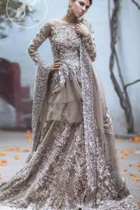 Bring out your beauty with this traditional yet modern zardosi embroidered frilled frock decorated with embellished floral motif and swarovski. It has full length floral embroidered sleeves. This outfit comes with heavy embellished lehenga which is enhanced with silver kora, dabka work and sprinkled sequins all over it. It is coordinated with beautiful dupatta with thick matha patti border on the front and intricate beautiful border on all rest of the three sides.