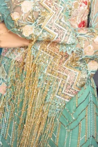 A must have creation for day to evening wear. Reflecting exuberant color play in this ethereal piece meticulously highlighted with swarovski, pearl, silver kora and dabka. It is also decorated with multiple color thread embroidery and golden tassels. It comes with full embroidered bell sleeves. This outfit is coordinated with raw silk bell bottom. The outfit comprises with tissue dupatta which is sprinkled with sequins on the ground.