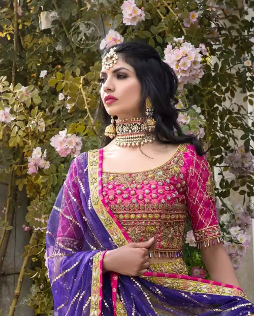 This dress is perfect for menhndi day. The shocking pink blouse is beautifully decorated with antique embroidery. It is highlighted