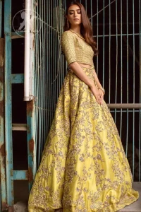 Tradition meets modernity. Exhibit elegance in this yellow blouse lehengha enhanced with kora and dabka embroidery adorned with Swarovski crystals and zardozi is perfect ensemble for mehendi. The outfit is coordinated with tissue dupatta with hand embroidered borders on all four sides and zardozi sequins work on the ground. It comes with raw silk fully embroidered lehengha.