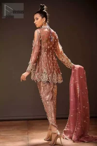 Take a step towards refreshing your wardrobe with this beautiful embroidered peplum. Beautiful embellishment created by artisans with hand done zardozi using resham, nakshi, dabki, hand cut sequins and dangling balls at the hemline. This meticulous wrap around peplum is also decorated with multiple color thread embroidery. Beautifully paired it up with copper rust tulip pants embellished with pearls. This outfit is comprises with organza dupatta with piping on all four sides and sequins spray all over.