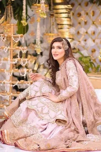Brighten up your look with this outfit on your reception or nikah day. Wear this soft and supple hues richly decorated by shades of golden and silver with gota work motifs and geometric patterns at daaman. Having embellished bodice and full length sleeves adorned with geometric patterns and motifs. Style it up with artfully coordinated tea pink gharara finessed with floral motifs and gota work details at the bottom. Thin border on all four sides of the dupatta which have gold tila embroidery with sequins, beads and crystal touching.