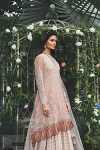 Ivory A Line Frock Sharara Net Dupatta. Go for this trendy dress, which is perfect for your nikah. Feel glamorous in our ivory a-line frock with fascinating embellishment on the neckline and silver kora, dabka, pearl, and sequins. The daman is emphasized with detailed matching embellishment and finished with a chocolate brown frill. It comprises a sharara adorned with a criss-cross pattern. This outfit is paired with a net dupatta focusing on kora and dabka handwork borders on all four sides, sequins spray all over, and finishes with tassels.