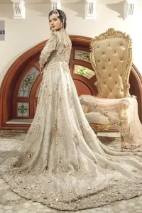 Bring out your beauty with this back trail maxi perfect for your big day. This bridal dress is beautifully sculptured with floral embroidery, adorned with cutwork borders embellished with silver kora, dabka, pearl and sequins work all over. The detailed resham and tilla work on the back of maxi and multiple floral motifs ornamented with gold kora and dabka embroidery on the bodice, the thick borders and floral bunches refined the classical royal look. Furthermore full length sleeves heavily embellished with zardosi work. It comprises with churidar pajama.