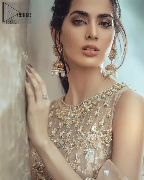 This bridal dress executing heavily hand crafted art of zardosi, kora and dabka with splashes of golden and silver is