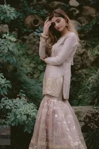 This dress is majestic beauty and perfect for your nikah or engagement day. Delicately crafted and personifying chic elegance with an element of grandiose. The beautiful neckline decorated with multiple color appliques, swarovski crystals and zardosi work. The daman is emphasized with golden kora, dabka,tilla and gota work to convey a classic look. Having full length sleeves adorned with tiny motifs scattered all over. This outfit is coordinated with self printed organza gharara. Pair it up with matching organza dupatta.