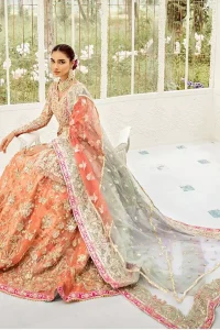 Captured in traditional silhouette, The bridal stands out due to its uniqueness and the perfect fusion of modern cut and traditional embroidery. This front open short frock is highlighted with kora, dabka, tilla, sequins and pearls. It comes with full embellished lehenga adorned with floral bunches, applique on the hemline and sequins spray all over it. It is coordinated with organza dupatta which is sprinkled with tiny floral motifs all over and a thick embellished border on all four sides with applique details.