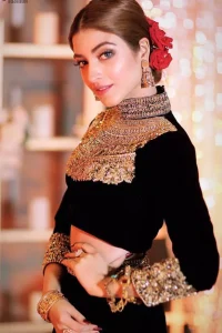 Embrace the season of festivities with this beautiful dress. This elegant ensemble turns timeless piece into a chic fantasy. The halter neck blouse is delicately hand crafted using the finest old age techniques and materials including kora, dabka, tilla, sequins, stones, and crystal. The sleeves are embellished with a thick embroidered border. Lehenga comprises of thick embroidered bottom to give it a regal look. It comes with a black net dupatta with sequins sprayed all over it .