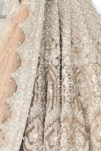 Paint a picture of pure elegance with this beautiful pishwas. This dress is beautifully sculptured with floral embroidery, adorned with geometric patterns embellished with silver kora, dabka, pearls and sequins work all over. The detailed scallop border gives a perfect ending to this pishwas. The lehenga is emphasized with embellished bottom that gives perfect ending to thisoutfit. It is coordinated with net dupatta sprinkled with chann all over and finished with embroidered border on four sides which makes this outfit more beautiful.