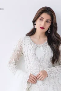 This is an ensemble that deserves to be flaunted. The ivory white shirt is an example of remarkable handiwork. With a lot of attention to detail, the intricate sequencing using glass beading and threads makes the shirt look like nothing but a dream. Furthermore the shirt is enhanced with thick embellished scalloped hemline. Sharara is magnificently decorated with scattered crystals all over. Beautifully paired it up with ivory white dupatta having four sided scalloped border.