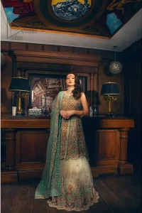 Classic, timeless and truly beautiful. Upholding the idea of simple is beautiful, you would definitely want to wear this outfit for your next occasion. The front open short frock is adorned with delicate arrangement of hand embellished floral patterns with multiple color thread embroidery and antique shaded zardozi work. The scalloped hemline done with champagne embellishment gives the right amount of glamour to the outfit. It coordinates with light fawn lehenga with scalloped bottom and heavy embellishment on it with zardozi. The look is completed with mint green organza dupatta with detailed work on the borders.