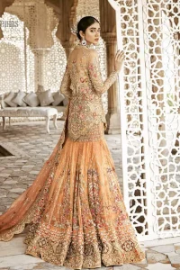 Beautifully elegant with a modern twist. Adorned in an orange embellished with antique detailing all over, this undeniably elegant attire will elevate your style. The shirt is ornamented with antique zardozi and multiple color embroidery detailing all over and vibrant floral motifs. Furthermore the hemline of the shirt is in cutwork style which adds twist. Paired it up with heavily embellished lehenga. The dupatta incorporates beautifully designed scalloped borders on all four sides, focusing on the heavily embellished pallu borders to give it a perfect look.