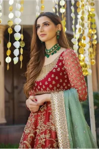 Make a special day even more magic with our exquisite bridal dress. This wedding dress is elegant and eye-catching in equal measure. Strike a breathtakingly elegant pose in this wedding dress, designed with a beautiful neckline embellished with sequins details and scattered tiny floral motifs all over. The lehenga is decorated with floral embroidery all over and finished with frilled fabric. The mint green organza dupatta with chann and finishing all around the edges makes the look complete.