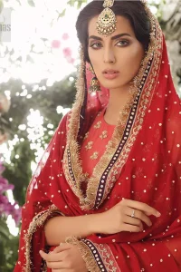 A perfect ensemble for this festive season with divine detailing of zardozi work. This outfit is an immensely captivating traditional piece, enhancing the art of classical heritage showcasing the craftsmanship of golden kora, dabka & tilla detailed with sequins, artistically embellished to give a beautiful rhythm to the outfit. Furthermore, the tiny floral booties scattered along the length. Complete the look with magenta churidar pajama and red chiffon dupatta adorned with sequins spray all over and four sided lace border.