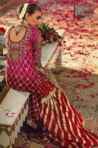 This elegant ensemble turns timeless piece into a chic fantasy. Crafted artfully with detailed work on border and traditional neckline finessed with kora, dabka and kundan. Shirt is furthermore enhanced with geometric patterns and scalloped lace hemline. It comprises with red sharara with embellished detailed bottom and gotta work. Style it up with red chiffon dupatta focusing on kora and dabka handwork scalloped borders on all four sides and sprinkled sequins on all over.