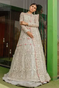 This garnet ensemble is sure to make you look like glamorous royalty with immaculate work covering every inch of the maxi. With a flowing train, this is an ensemble that deserves to be flaunted. The maxi is crafted artfully with silver zardozi work and multiple color thread embroidery. The bodice is heavily decorated with silver kora, dabka and tilla work. Furthermore, scattered sequins all over to give it a perfect look. Balance the look with light gray lehenga adorned with frilled bottom. Dupatta is decorated with vintage floral on pallus and finished with embroidered border on four sides which makes this outfit more beautiful.