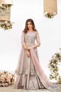 Embrace the season of festivities with this beautiful dress. Dazzle in this made to perfection, richly embroidered net outfit decorated with intricate embroidered front highlighted with silver and light golden zardozi work borders on daaman and embroidered stripes on sleeves. The bodice is fully furnished with zardozi work and sprinkled with floral motifs around neckline. The outfit is comprises with brocade sharara and tea pink net dupatta adorned with sequins spray all over.