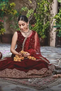 Let the crowd stare and make it worth their while when you walk wearing this maroon velvet lehenga blouse. Designed to flaunt your best features, the sleeveless blouse carries sequins spray with round neckline. Upholding the idea of simple is beautiful, you would definitely want to wear this for your next occasion or on your big day. The blouse is paired with maroon lehenga with hand embellishments on velvet base. The wide flare lehenga hemline is emphasized with intricate details with antique shaded kora, dabka, tilla and sequins work that gives the perfect ending t this outfit. Paired with maroon net dupatta having lace on all four sides.