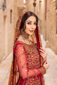 Make your big day more beautiful with our excessively embroidered back train lehenga shirt featuring delicately embellished neckline along with geometric patterns highlighted in antique shaded embroidery detailing and intricately embroidered borders that gives perfect ending to this outfit. Pair it up with a breathtaking back train lehenga with scattered motifs on the ground and embellished hemline. The orange organza dupatta with floral motifs and finishing all around the edges makes the look complete. The combination of orange with red is absolutely breathetaking.